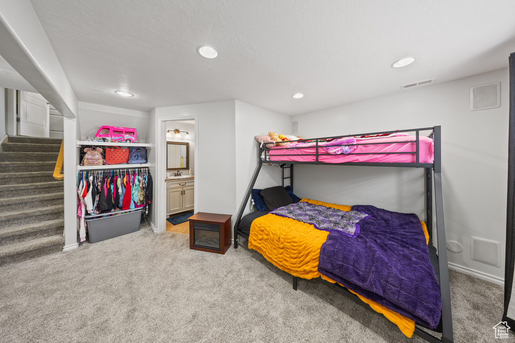 Bedroom featuring carpet, recessed lighting, and ensuite bath