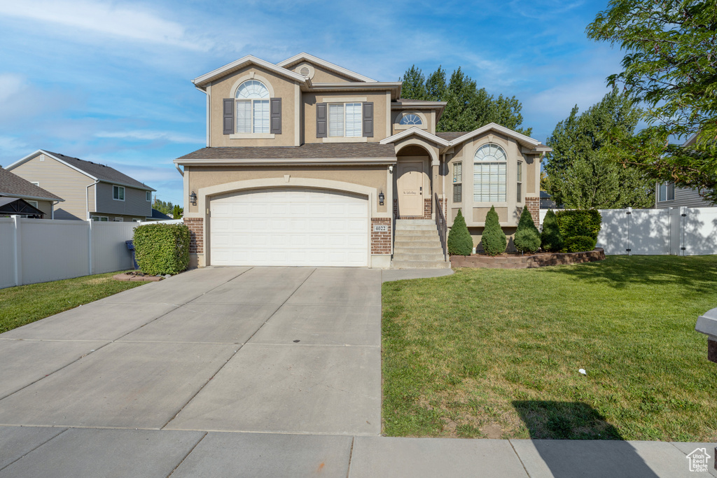 View of front of property featuring stucco siding, a garage, concrete driveway, and brick siding