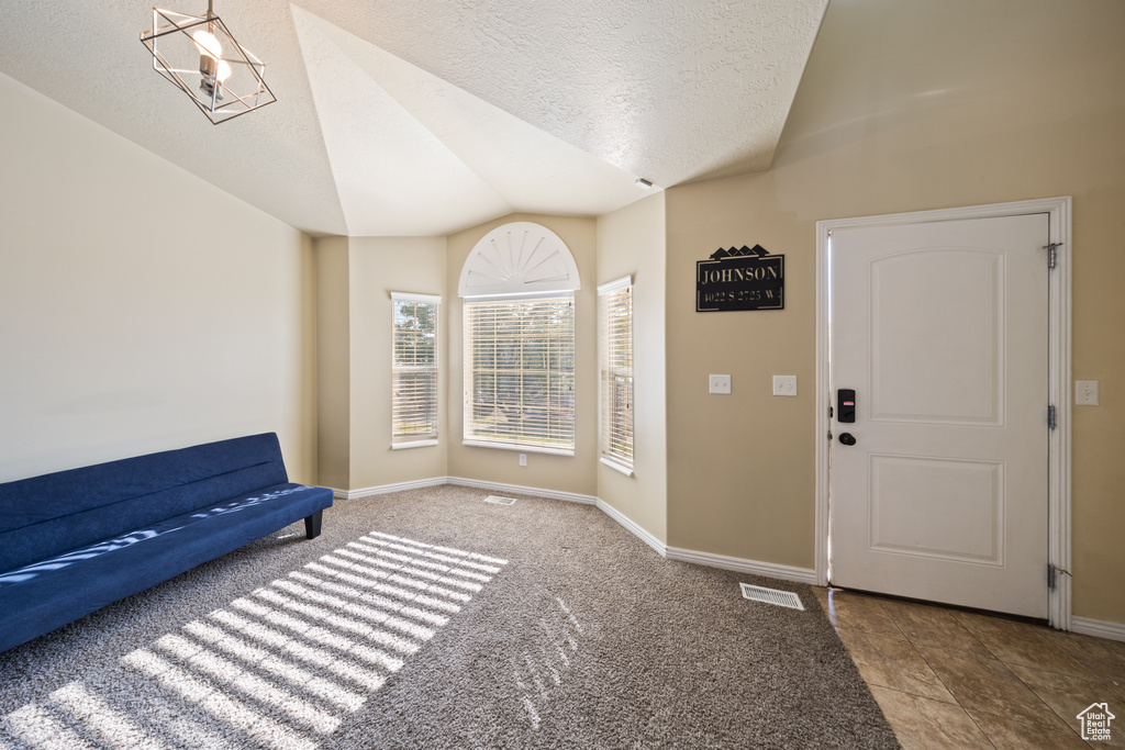Foyer with lofted ceiling and a textured ceiling
