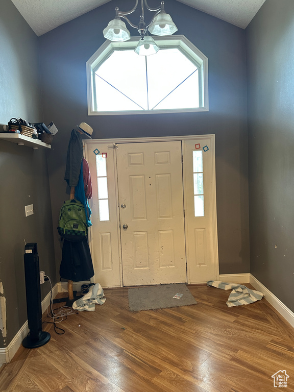 Entryway featuring wood finished floors, a chandelier, and a textured ceiling