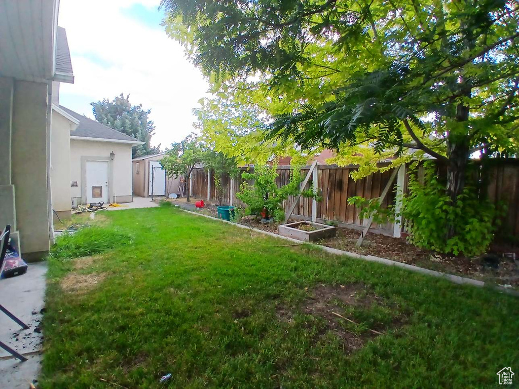 Fenced backyard featuring a storage unit