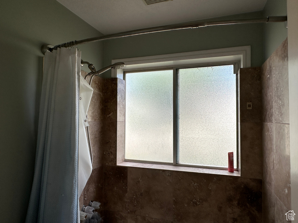 Bathroom featuring a shower with curtain