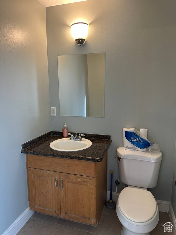 Half bathroom with vanity and tile patterned floors