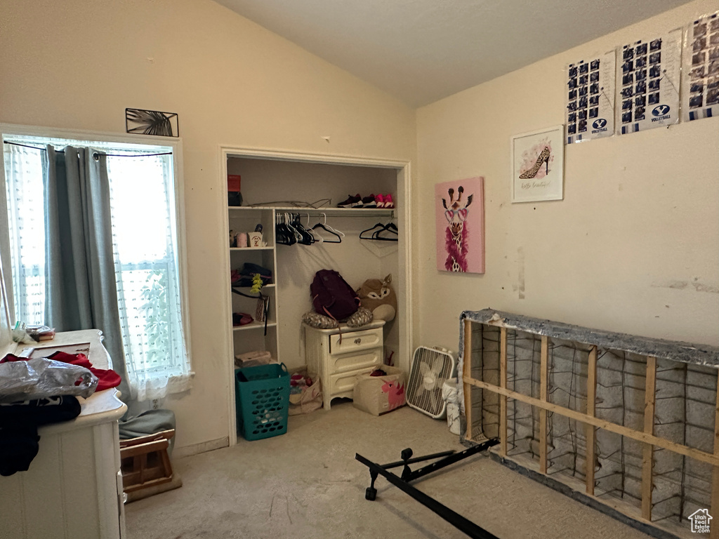 Bedroom with vaulted ceiling, a closet, and carpet flooring