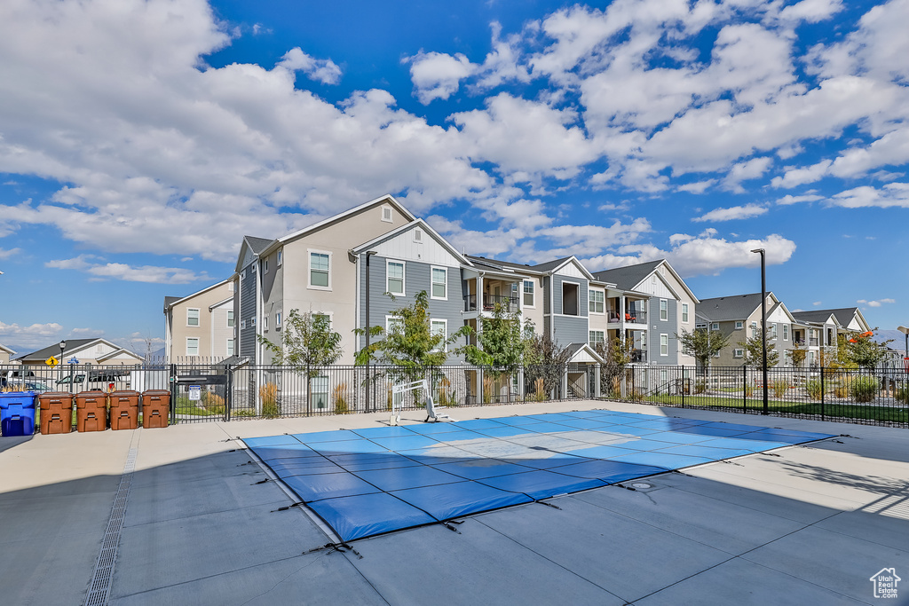 View of basketball court with a residential view and a community pool