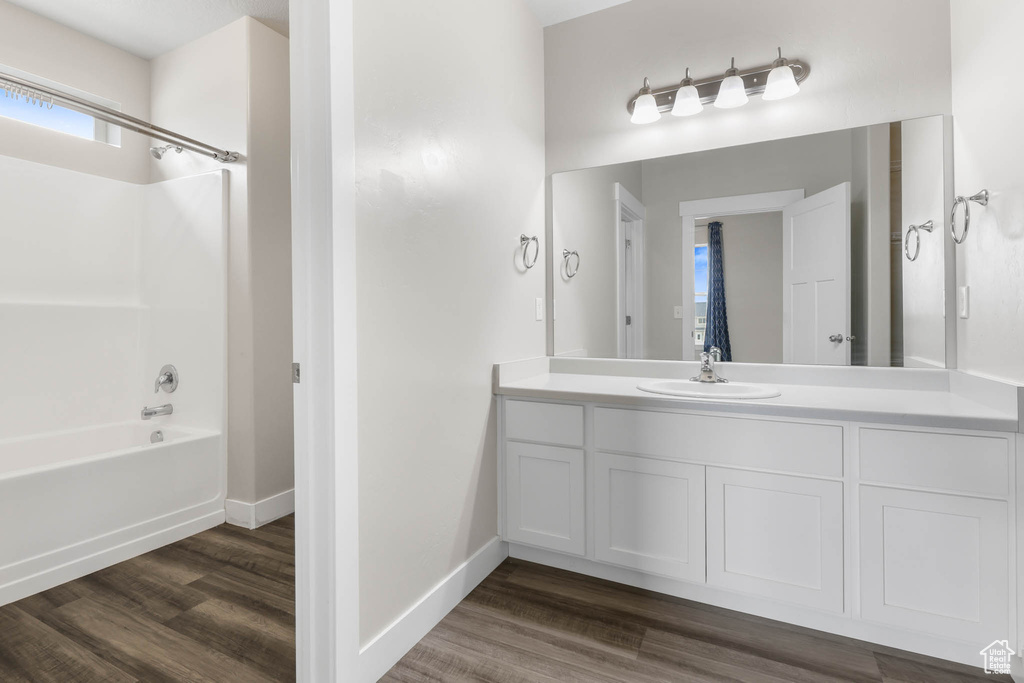 Bathroom featuring shower / bath combination, wood finished floors, and vanity