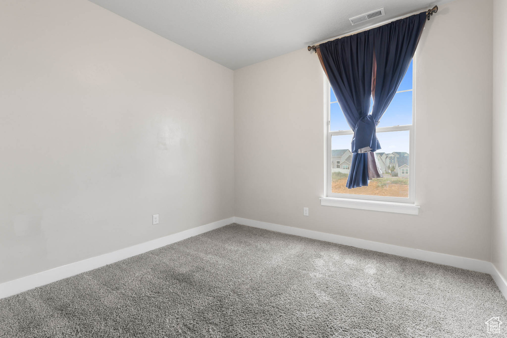 Carpeted empty room with baseboards
