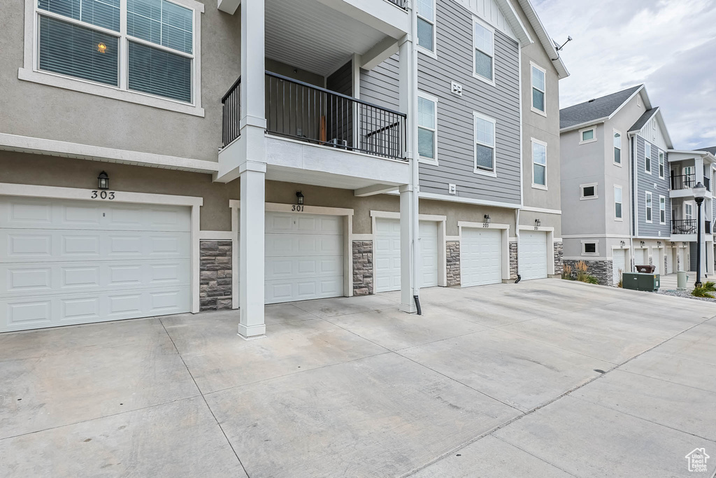 View of property featuring an attached garage, a residential view, and driveway