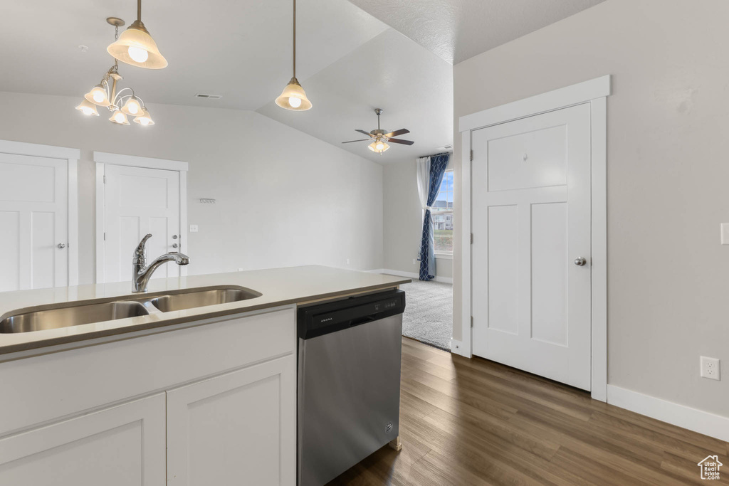 Kitchen with dishwasher, pendant lighting, dark wood-style floors, white cabinetry, and vaulted ceiling