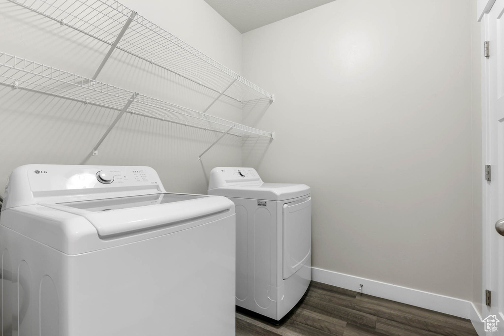 Laundry area with washing machine and clothes dryer and dark wood-style floors