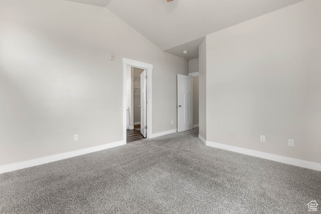 Spare room with carpet flooring and lofted ceiling