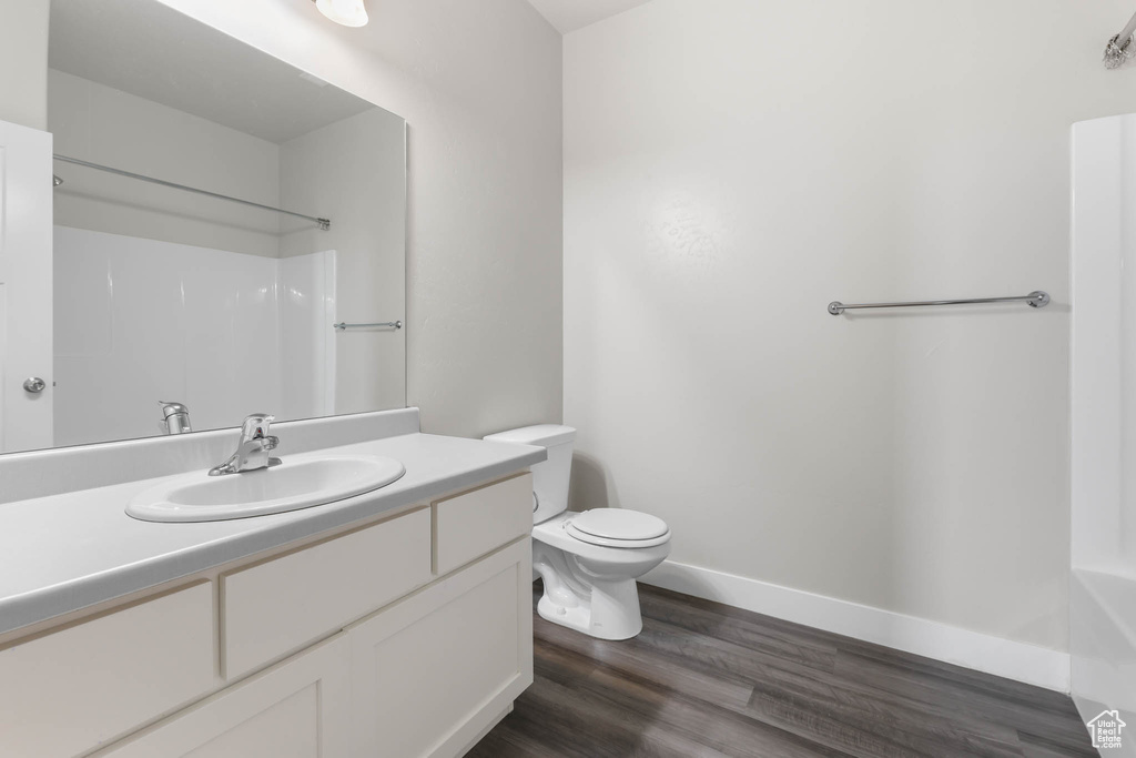 Full bathroom with vanity, wood finished floors, and a shower