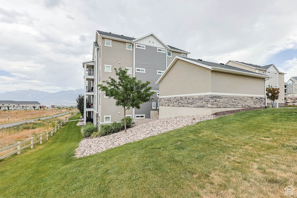 View of side of property featuring stucco siding, a mountain view, and stone siding