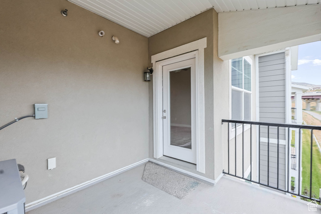Doorway to property with stucco siding and a balcony