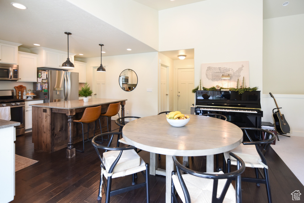 Dining area with dark wood finished floors and recessed lighting