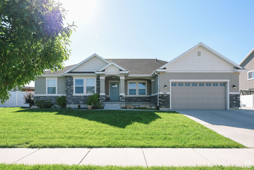 Craftsman-style house featuring stone siding, a garage, concrete driveway, and stucco siding