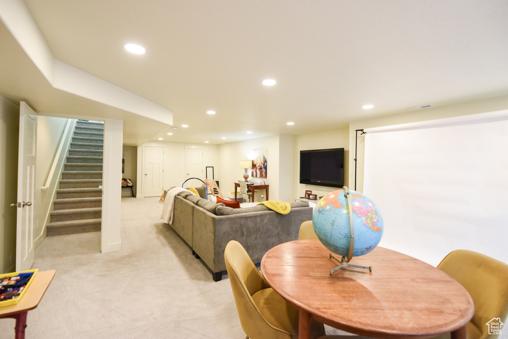 Living room with light carpet, recessed lighting, and stairway