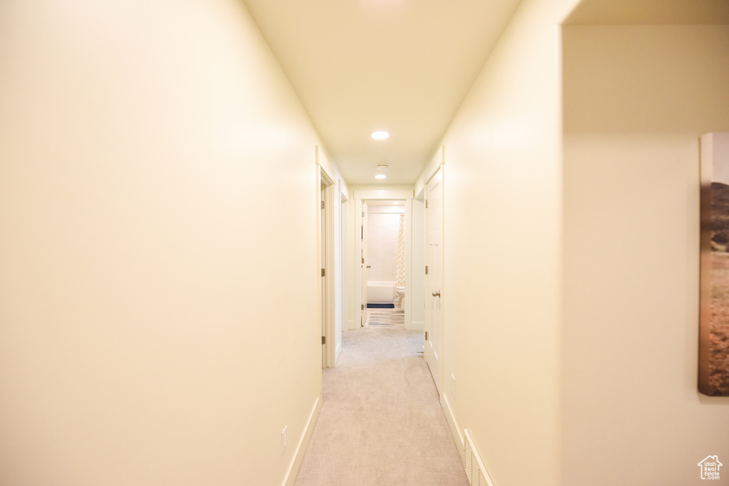 Corridor featuring recessed lighting and light colored carpet
