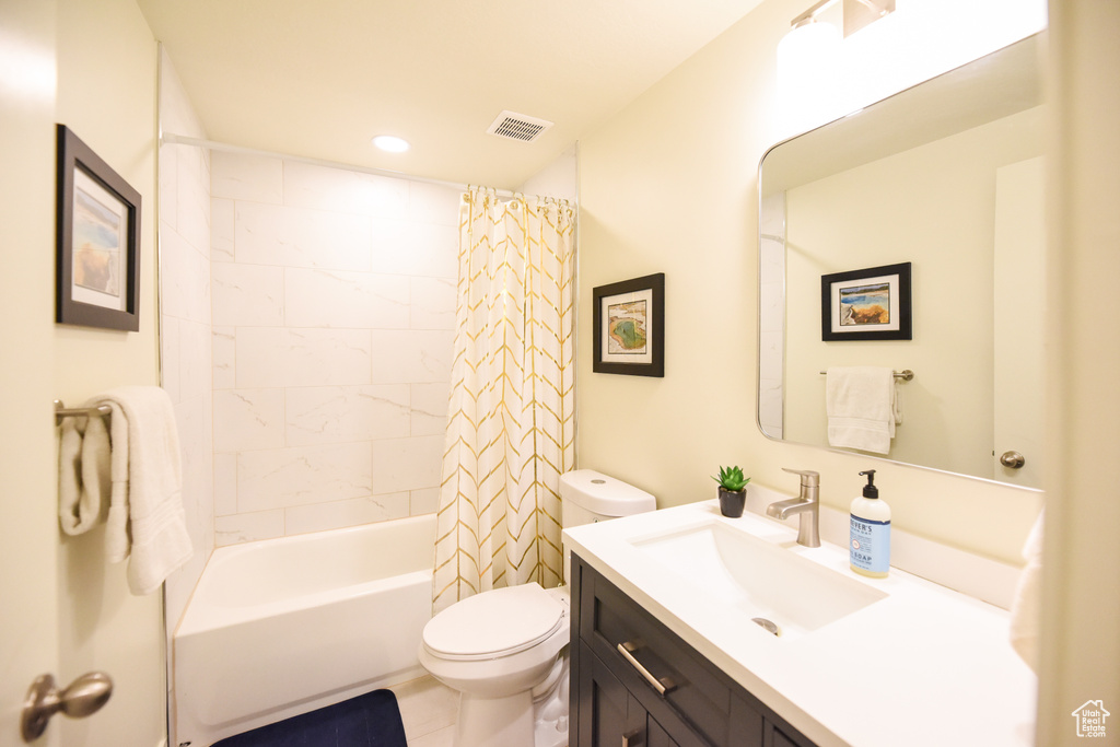 Bathroom with vanity, shower / bathtub combination with curtain, and recessed lighting