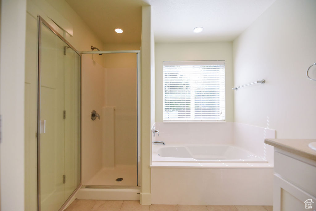Bathroom with a bath, a stall shower, vanity, tile patterned floors, and recessed lighting
