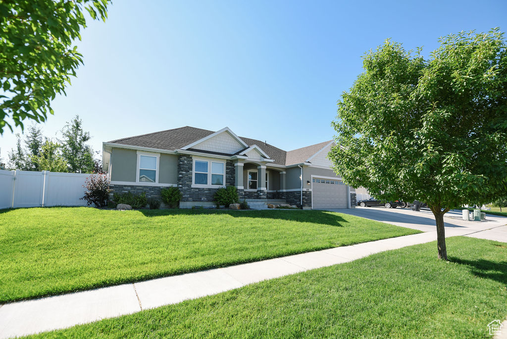 Craftsman-style home featuring stone siding, a garage, concrete driveway, and stucco siding