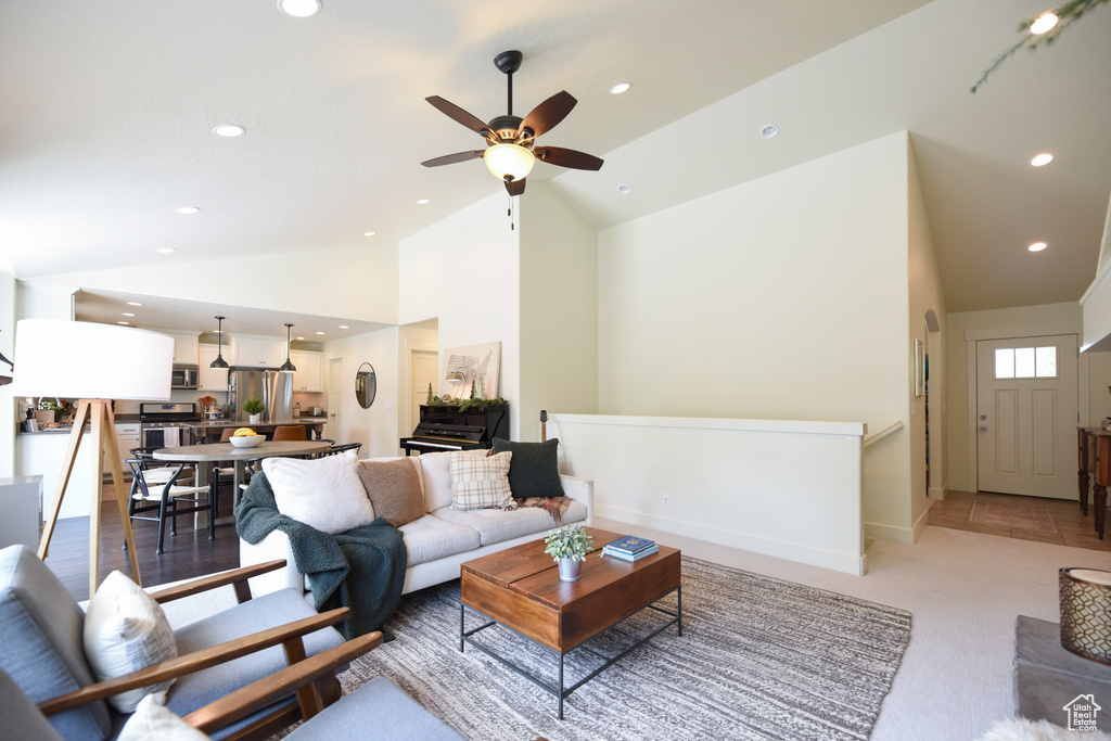 Living area featuring vaulted ceiling, recessed lighting, ceiling fan, and light carpet