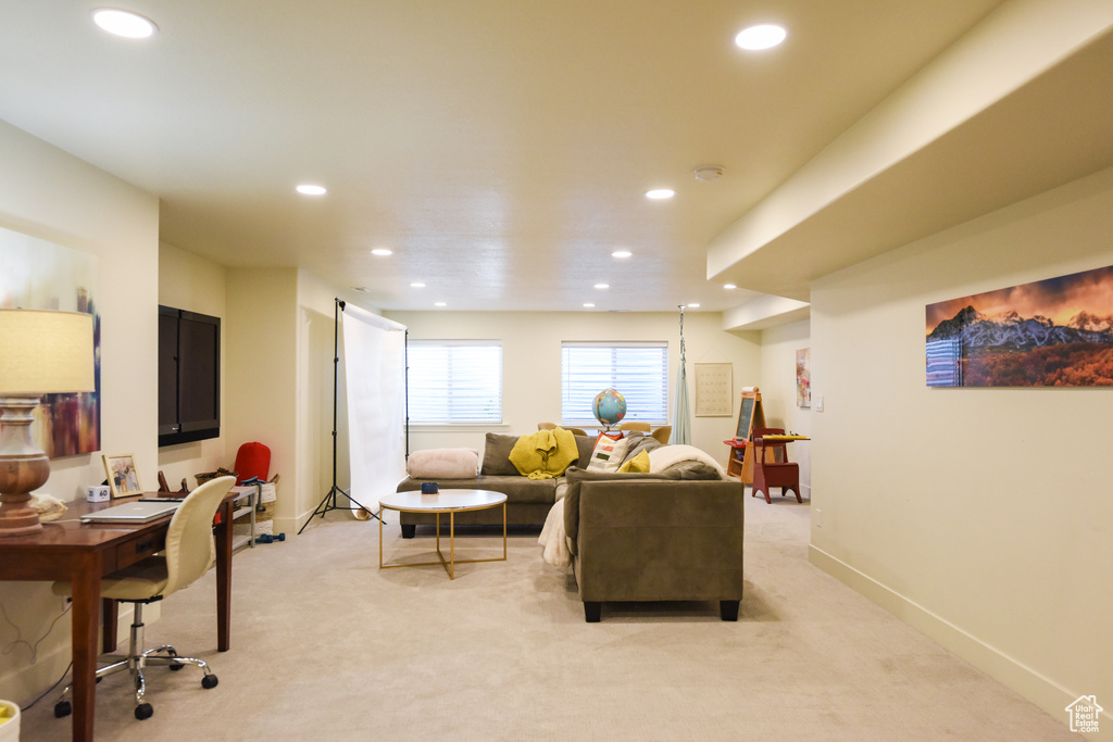 Living area featuring light colored carpet, recessed lighting, and a desk