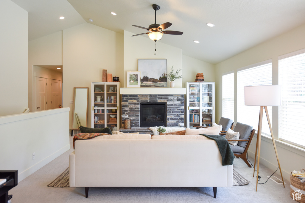 Living area featuring light carpet, a ceiling fan, a stone fireplace, recessed lighting, and high vaulted ceiling