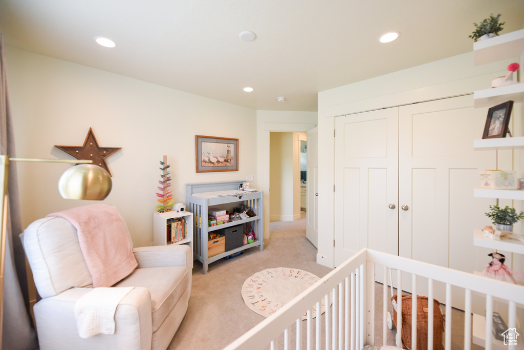 Bedroom featuring light carpet, a closet, recessed lighting, and a crib
