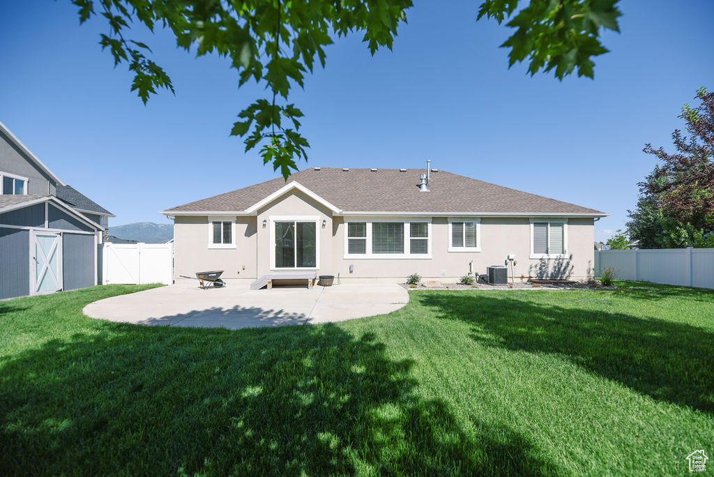 Rear view of property featuring a patio, stucco siding, a fenced backyard, a shingled roof, and a gate