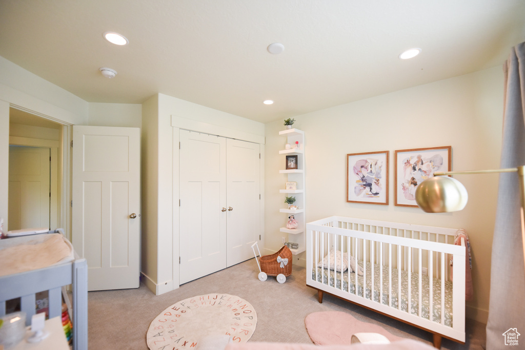 Bedroom with recessed lighting, a closet, carpet, and a nursery area