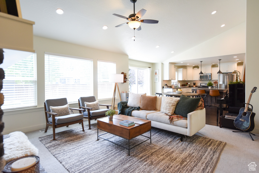 Living room with light carpet, ceiling fan, vaulted ceiling, and recessed lighting