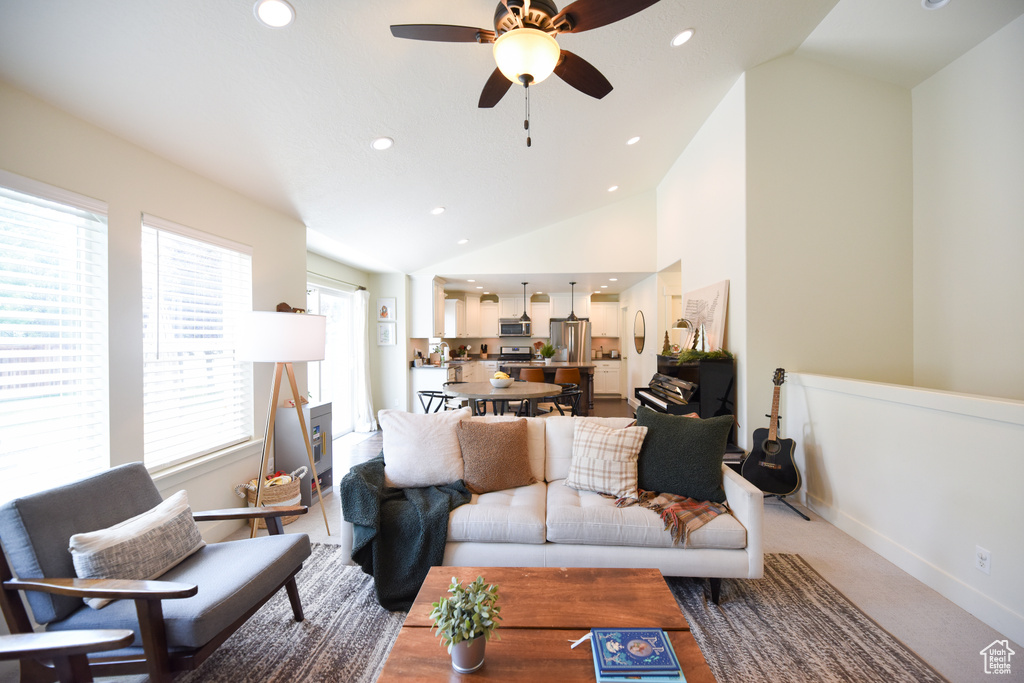 Living area with lofted ceiling, a ceiling fan, recessed lighting, and light colored carpet