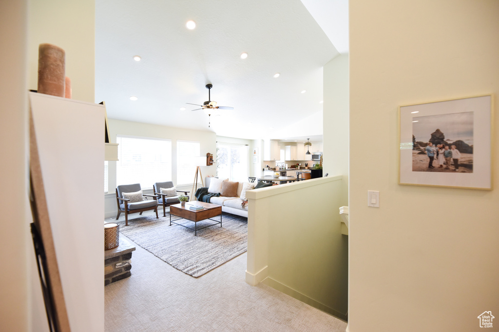 Living area with ceiling fan, recessed lighting, and light colored carpet