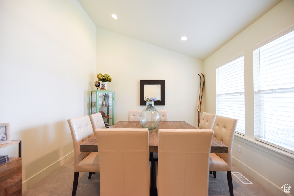Dining space featuring carpet flooring, lofted ceiling, healthy amount of natural light, and recessed lighting