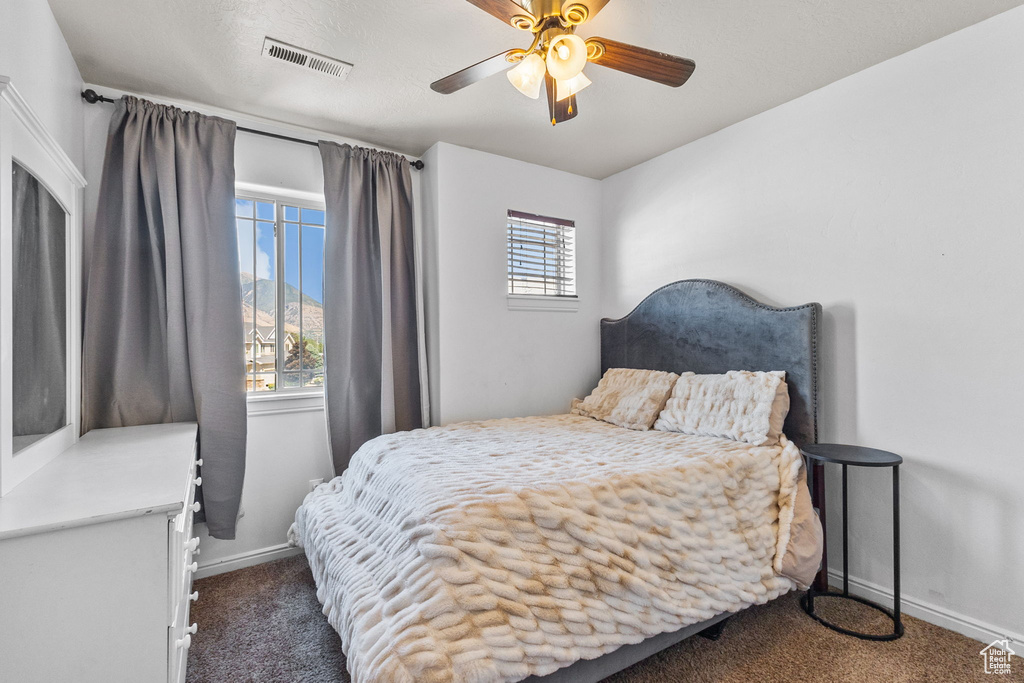 Carpeted bedroom featuring baseboards and a ceiling fan