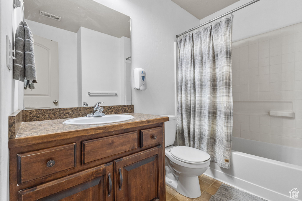 Bathroom featuring vanity, shower / bathtub combination with curtain, and tile patterned floors