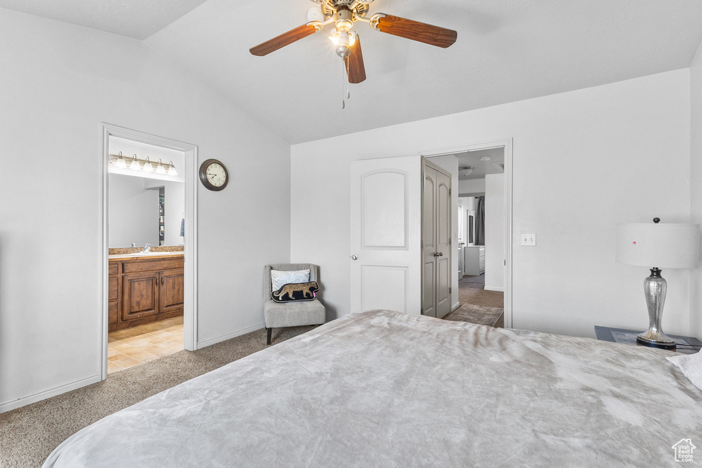 Bedroom featuring carpet flooring, vaulted ceiling, ceiling fan, and connected bathroom