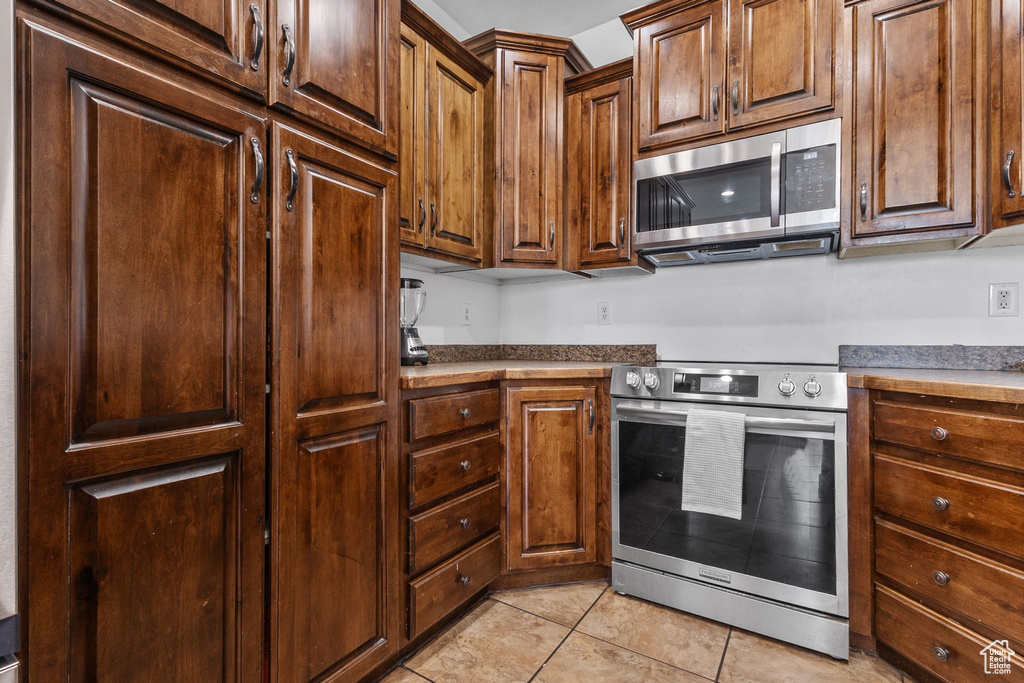 Kitchen with stainless steel appliances and light tile patterned floors