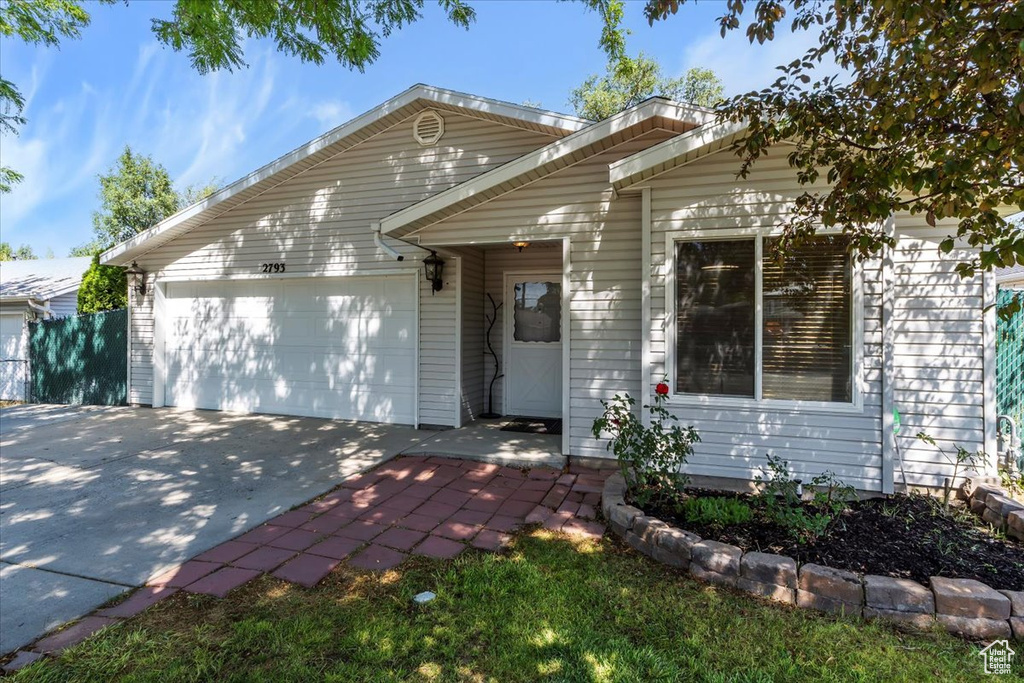 View of front of property featuring an attached garage and driveway