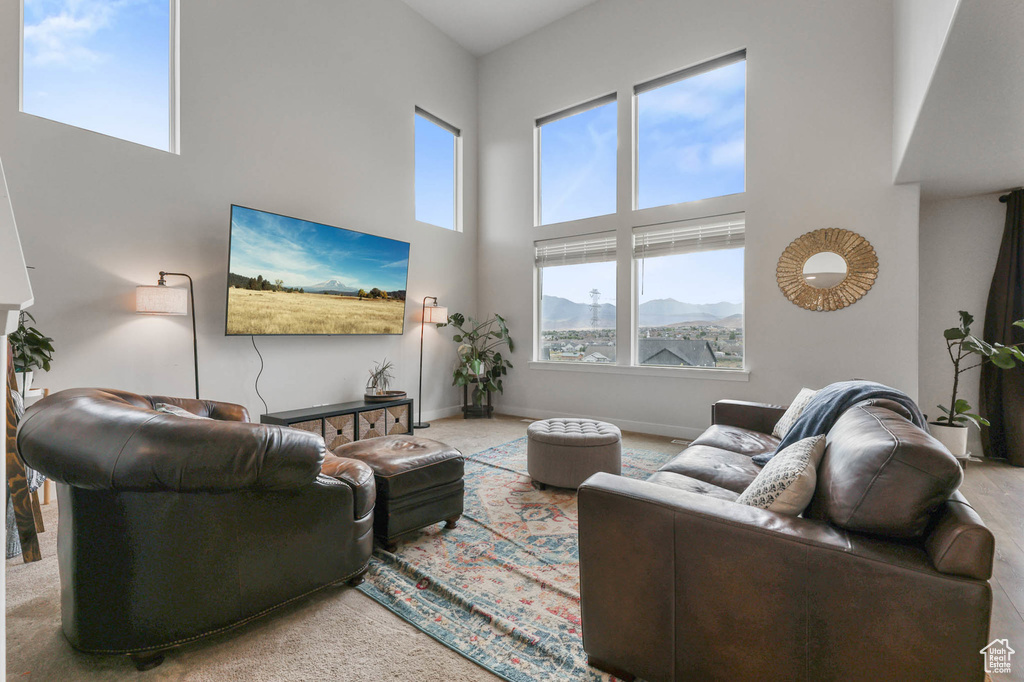 Carpeted living area with a towering ceiling and baseboards