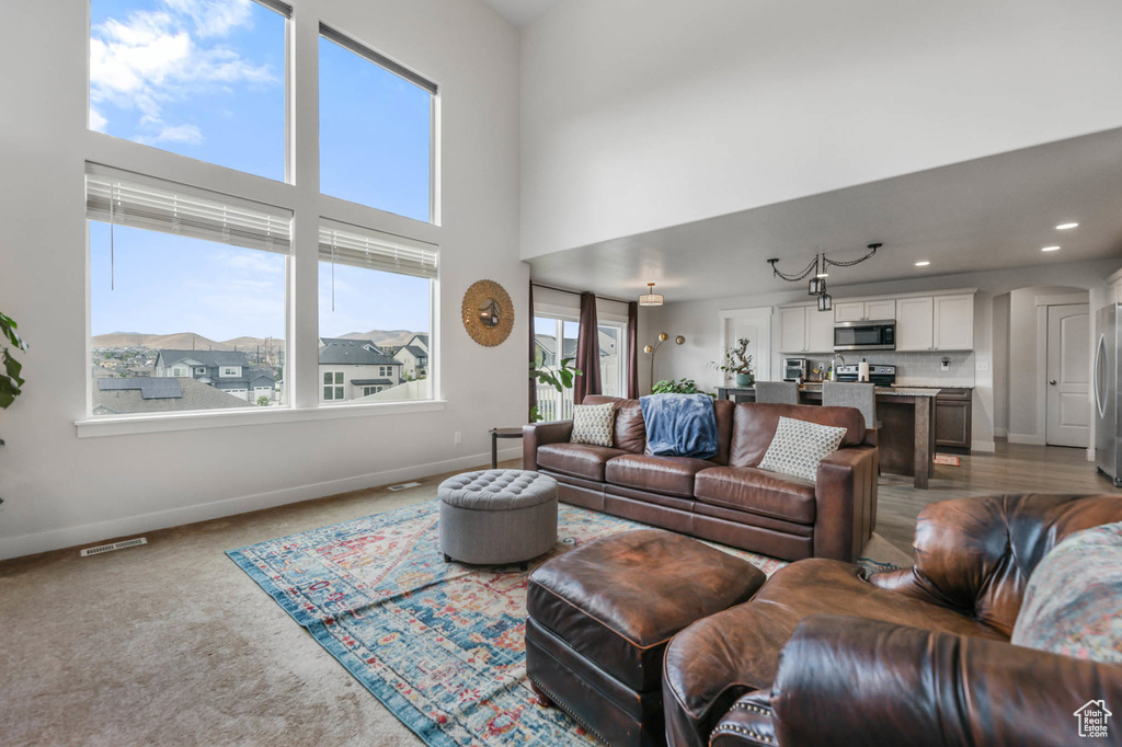 Carpeted living room featuring a high ceiling and recessed lighting