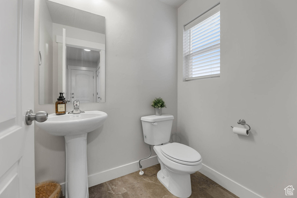Half bathroom featuring baseboards and toilet