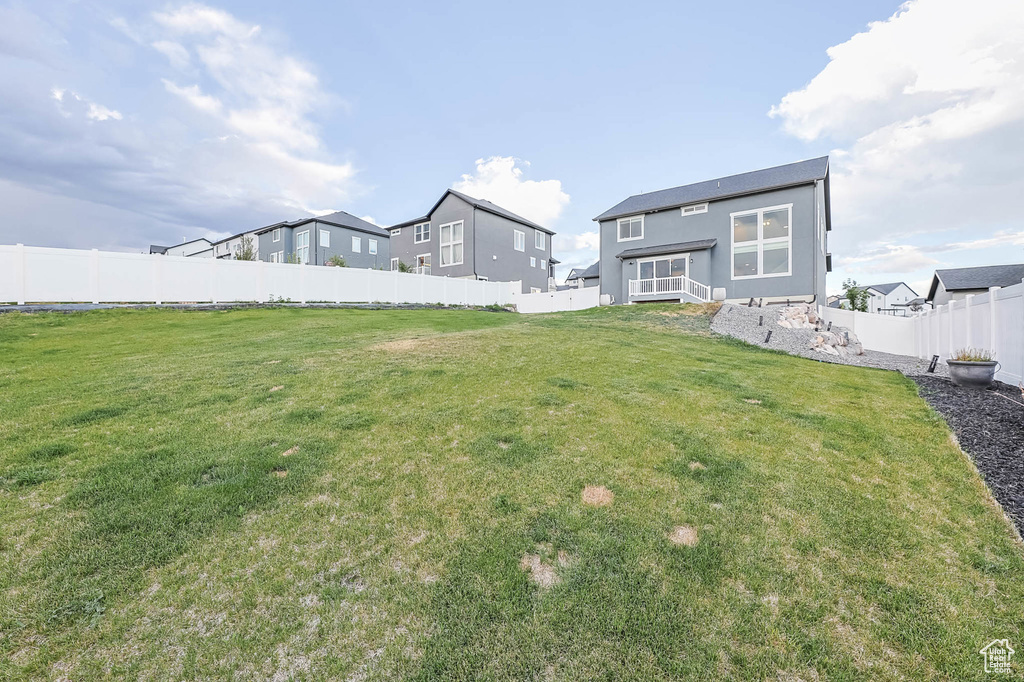 Back of property with a fenced backyard and stucco siding