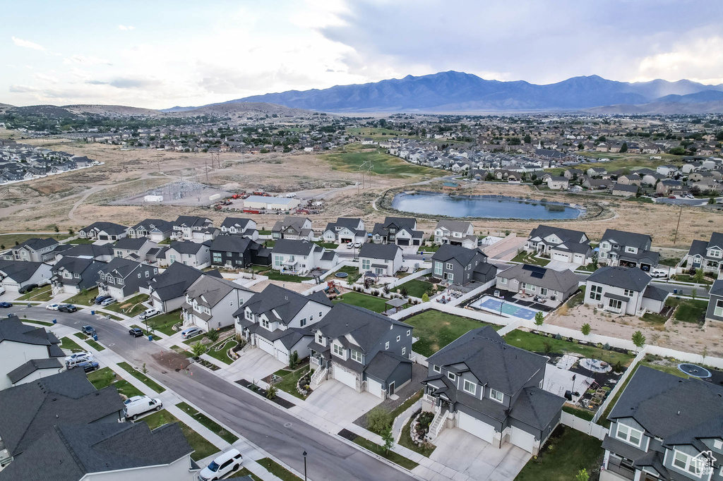 Aerial view of property and surrounding area with a water and mountain view and nearby suburban area