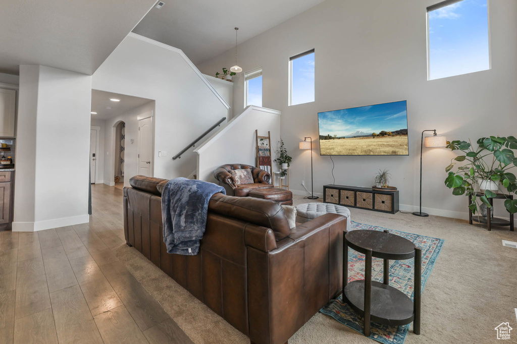 Living area with a high ceiling, stairs, arched walkways, and recessed lighting