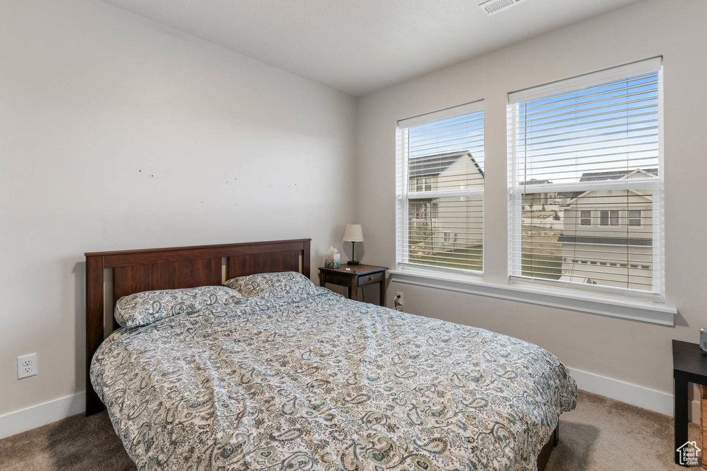 Bedroom featuring carpet and baseboards
