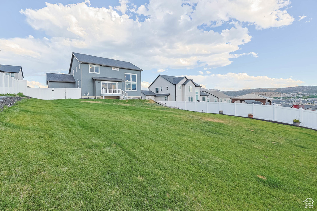 Back of property with a fenced backyard and stucco siding
