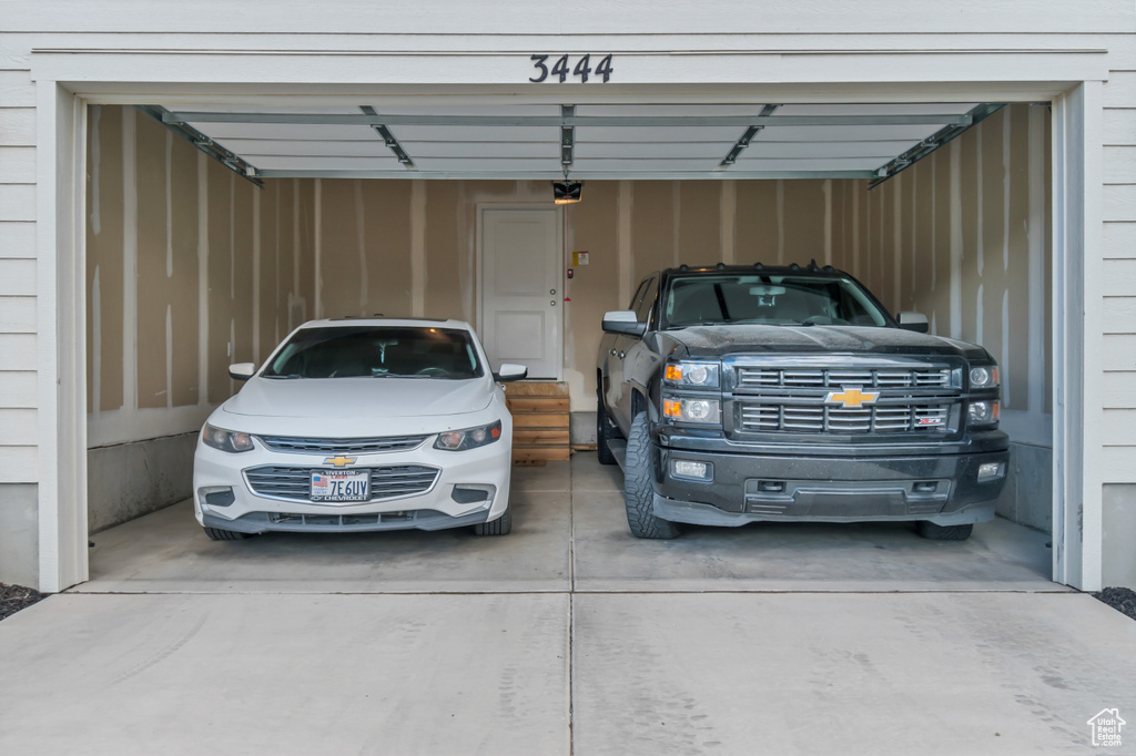 Garage with concrete driveway and a garage door opener