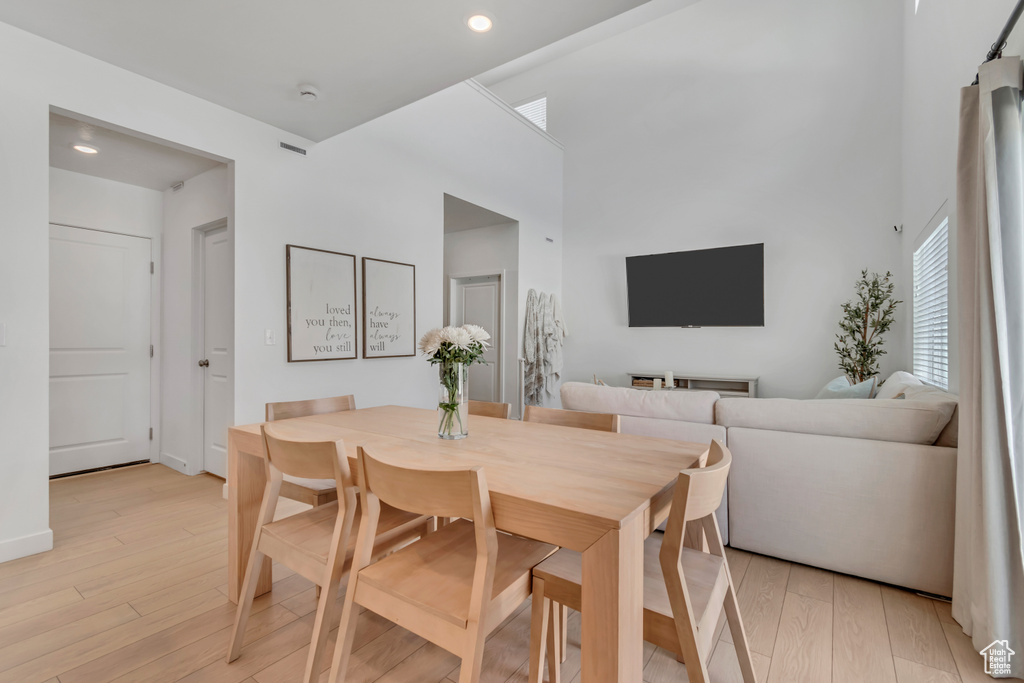 Dining space with light wood finished floors and recessed lighting